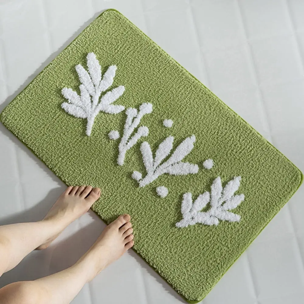 Olivgrüne Badematte mit weißen Blattmotiven, weiches Material, ideal für Badezimmer.