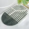 Ovaler Badteppich mit schwarz-weißem Streifenmuster, modernes Badezimmer Design.