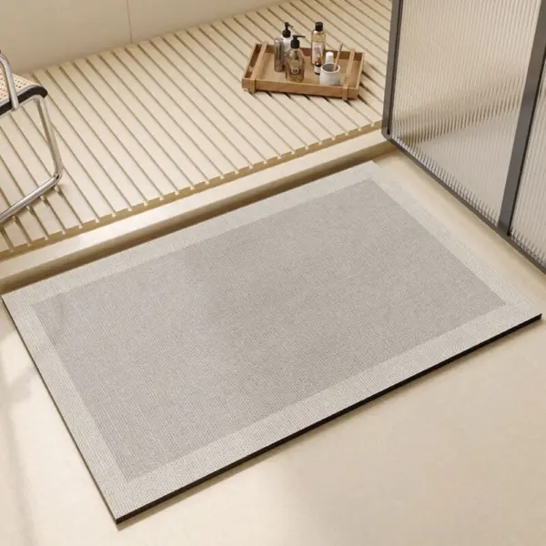 Perlgrauer Badteppich mit schwarzem Rand, ideal für moderne Badezimmer.