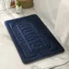 Rechteckige Badematte dunkelblau mit Relief-Design HOME, für Badezimmer.