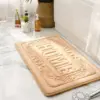 Rechteckige Badematte mit HOME-Relief, beige, für Badezimmer, weich und strapazierfähig.