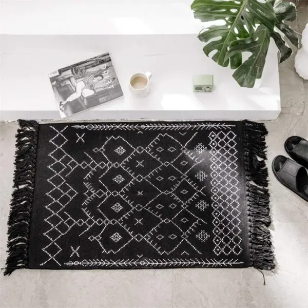 Schwarze Baumwoll-Badematte mit geometrischem Muster und Fransen, ideal für Badezimmer.