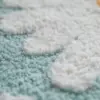 Skandinavischer Badteppich mit weissem Wolkenmuster auf türkisfarbenem Grund, weiches Material für Badezimmer.