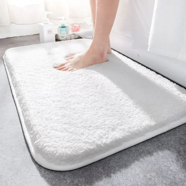 Weisser, super-saugfähiger Badteppich mit weicher Oberfläche und rutschfestem Rand, ideal für Badezimmer.
