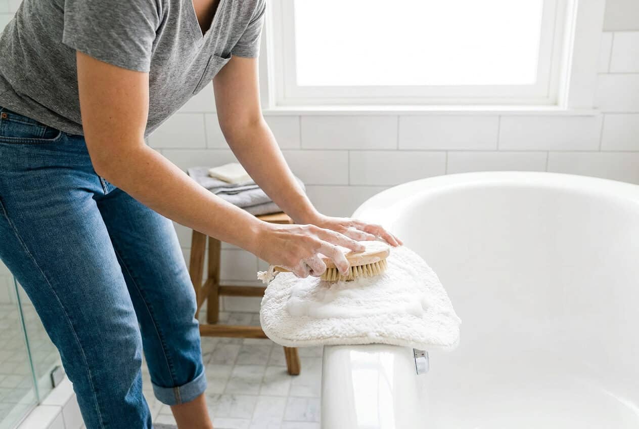 Badteppich wird in der Badewanne mit einer weichen Bürste gewaschen
