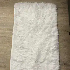 Flauschige Badematte in Weiss auf Holzboden